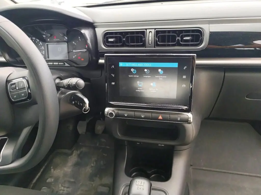 Vue intérieure côté conducteur du tableau de bord noir de la Citroën C3 Société 2019 avec écran tactile et boîte manuelle.