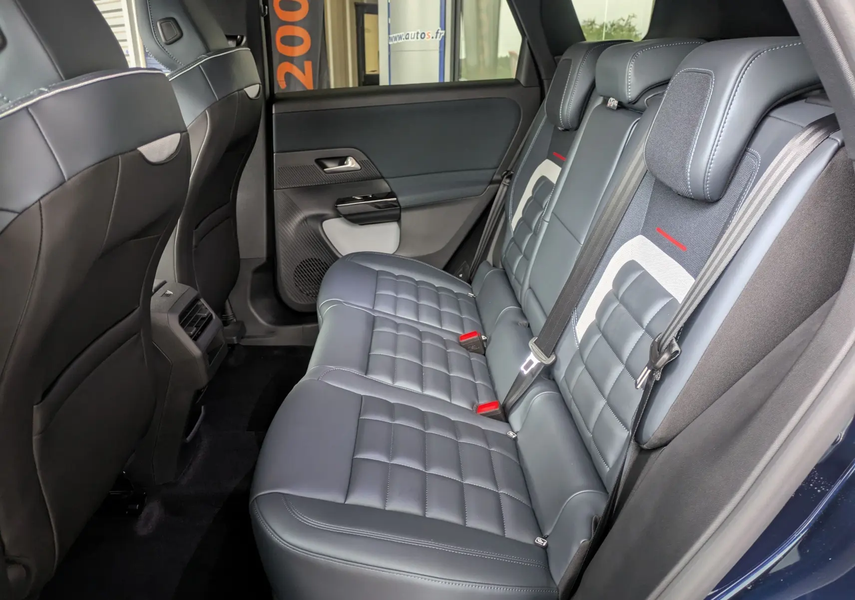 Vue intérieure côté droit des sièges arrière en cuir noir avec surpiqûres blanches du Citroën C5 Aircross hybride 2026.