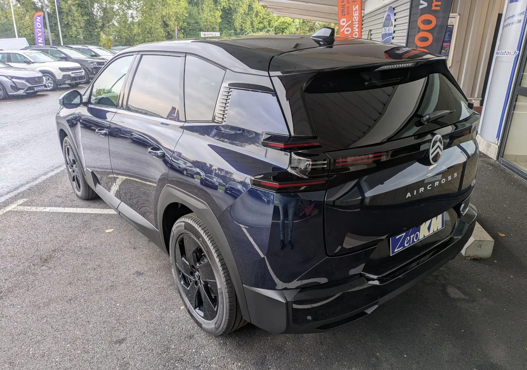 Vue 3/4 arrière droite du Citroën C5 Aircross hybride bleu Eclipse avec toit noir et jantes noires.