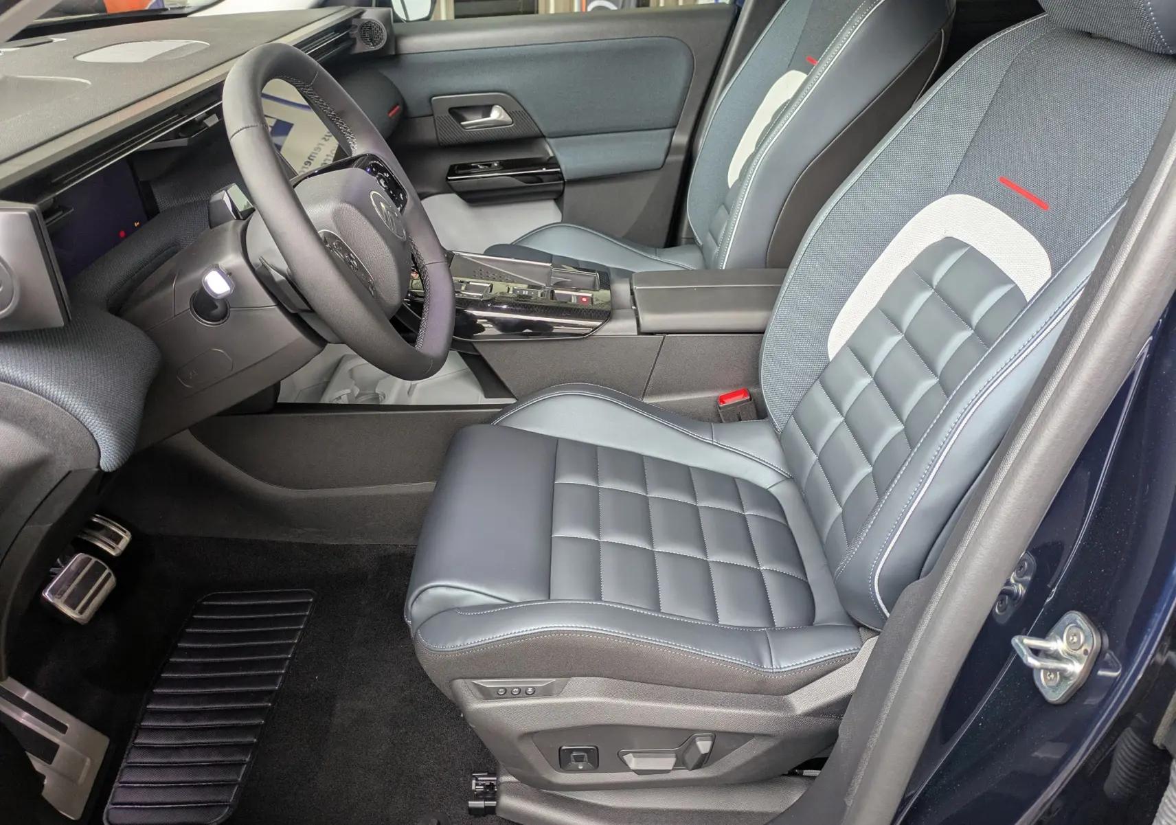 Vue intérieure côté conducteur du Citroën C5 Aircross hybride 2026, sièges en cuir bleu avec surpiqûres et console centrale noire brillante.
