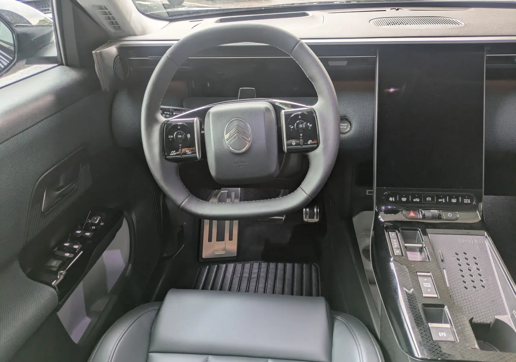Vue intérieure avant du Citroën C5 Aircross hybride 2026, volant compact et console centrale avec écran tactile vertical.