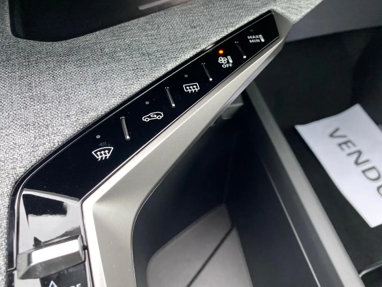 Gros plan sur la console centrale de la Peugeot 3008 Hybrid 2026, montrant les commandes tactiles du système de climatisation.