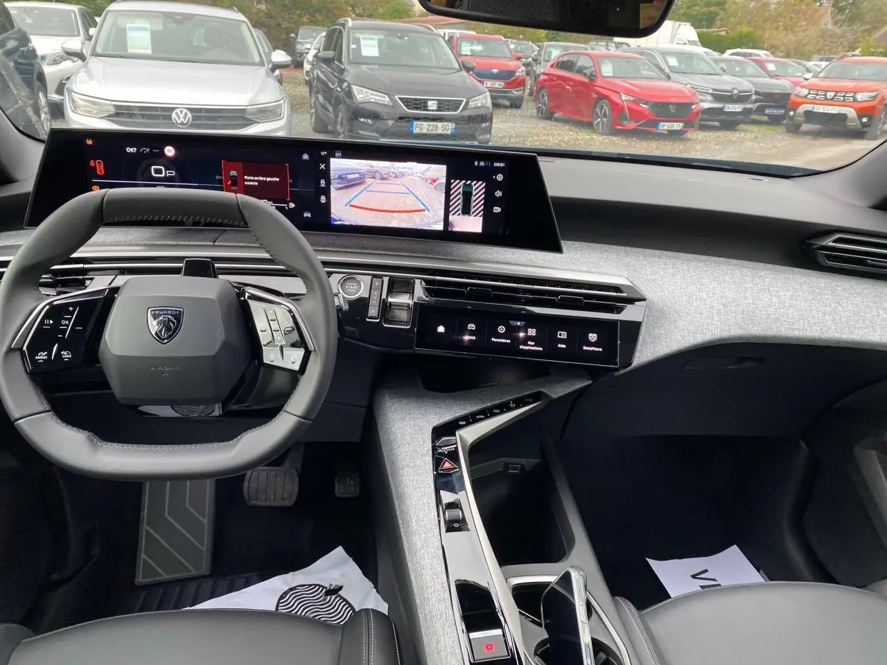 Vue intérieure avant du Peugeot 3008 Hybrid 2026 montrant le volant compact, le tableau de bord numérique incurvé et la console centrale moderne.