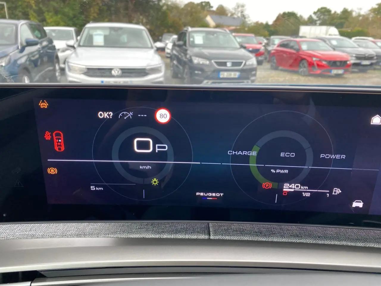 Vue intérieure du tableau de bord numérique du Peugeot 3008 Hybrid avec affichage de la vitesse et autonomie, en stationnement.