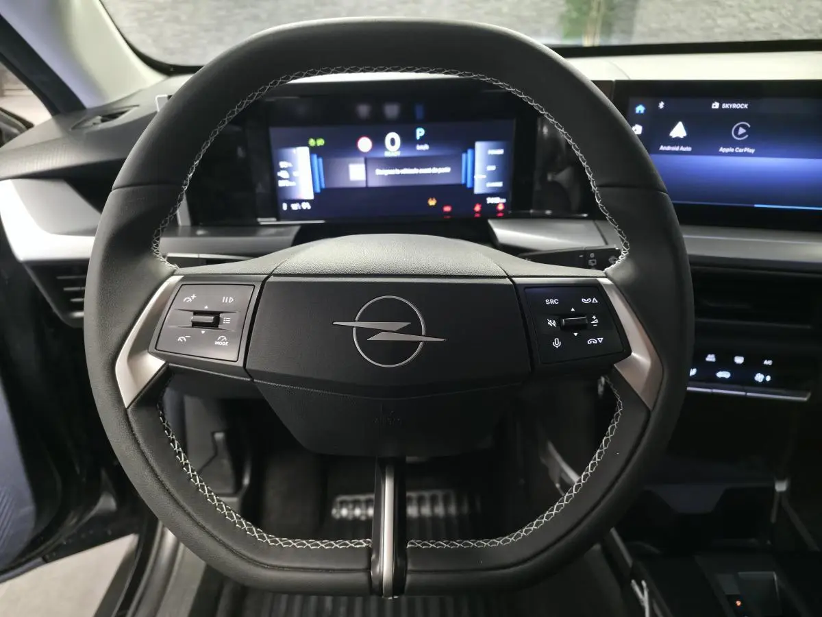 Vue rapprochée du volant noir avec logo Opel au centre et tableau de bord numérique du Frontera-e 2025.