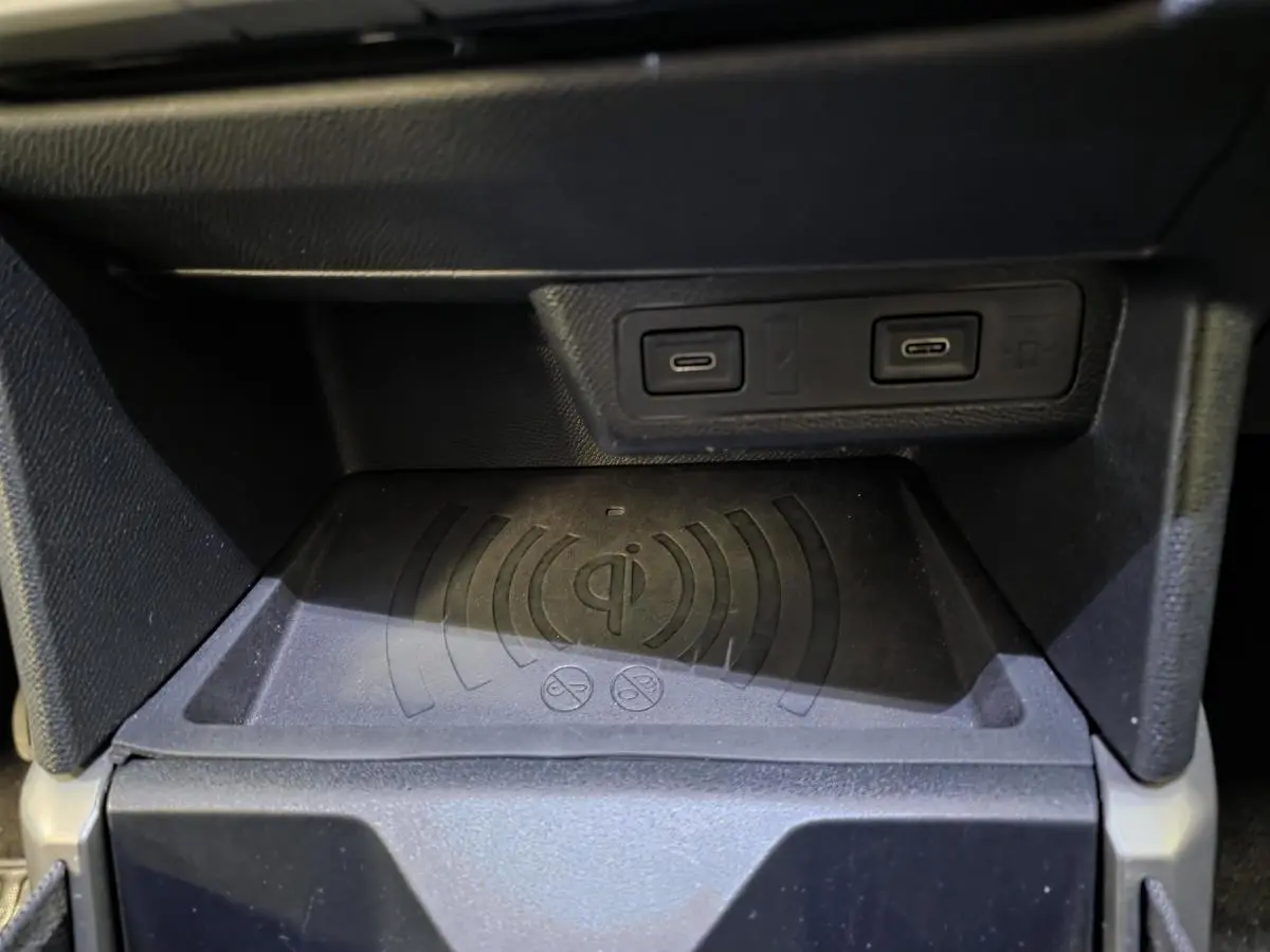 Gros plan sur la console centrale noire du Opel Frontera-e 2025 avec deux ports USB-C et chargeur sans fil Qi.
