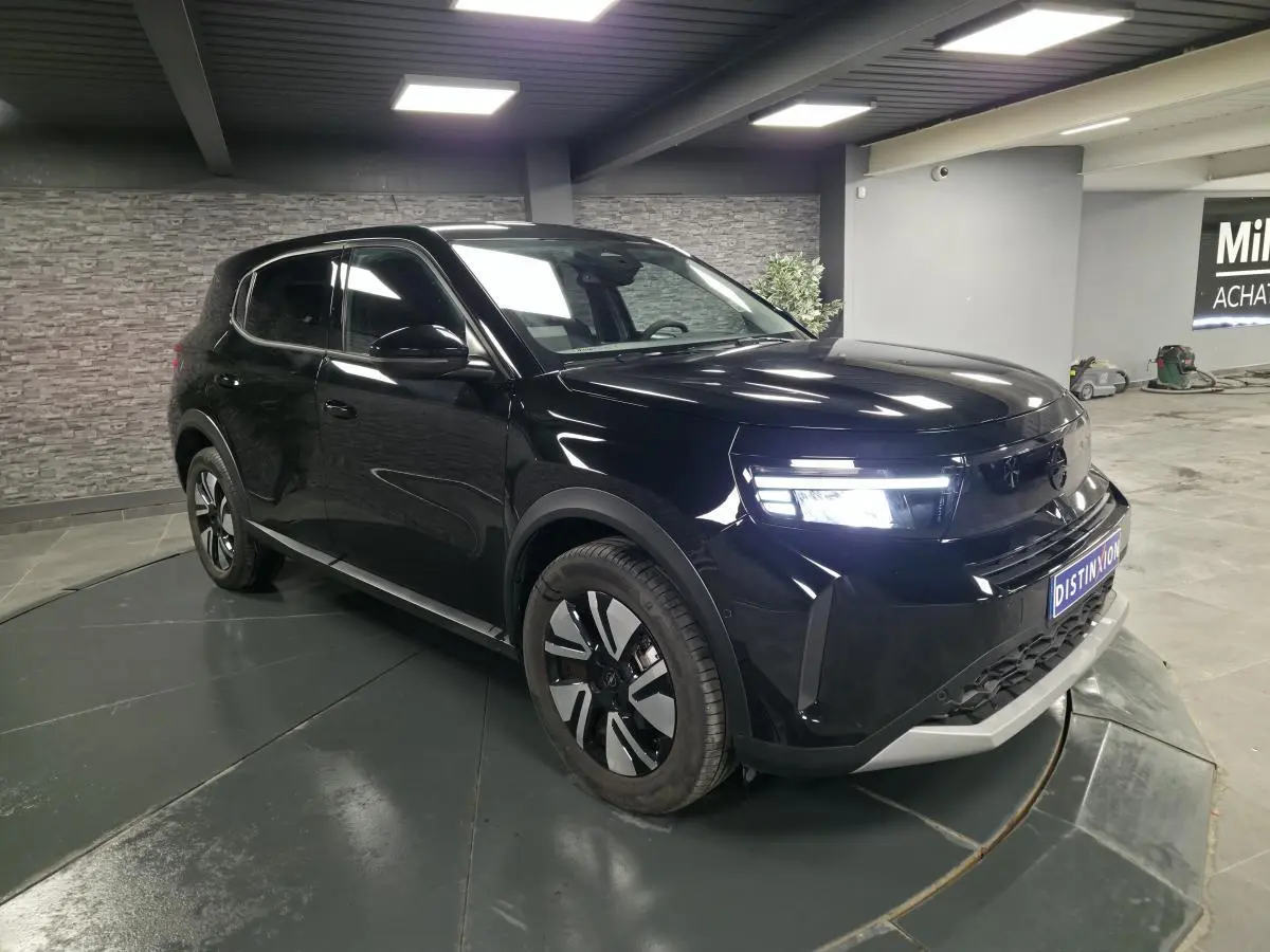 SUV Opel Frontera-e noir métallisé vu en 3/4 avant droit avec calandre Vizor et jantes alliage 17 pouces.