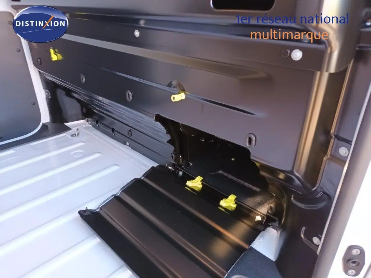 Vue intérieure du coffre du FIAT Scudo Fourgon blanc 2022, mettant en valeur la cloison arrière noire avec fixations jaunes.