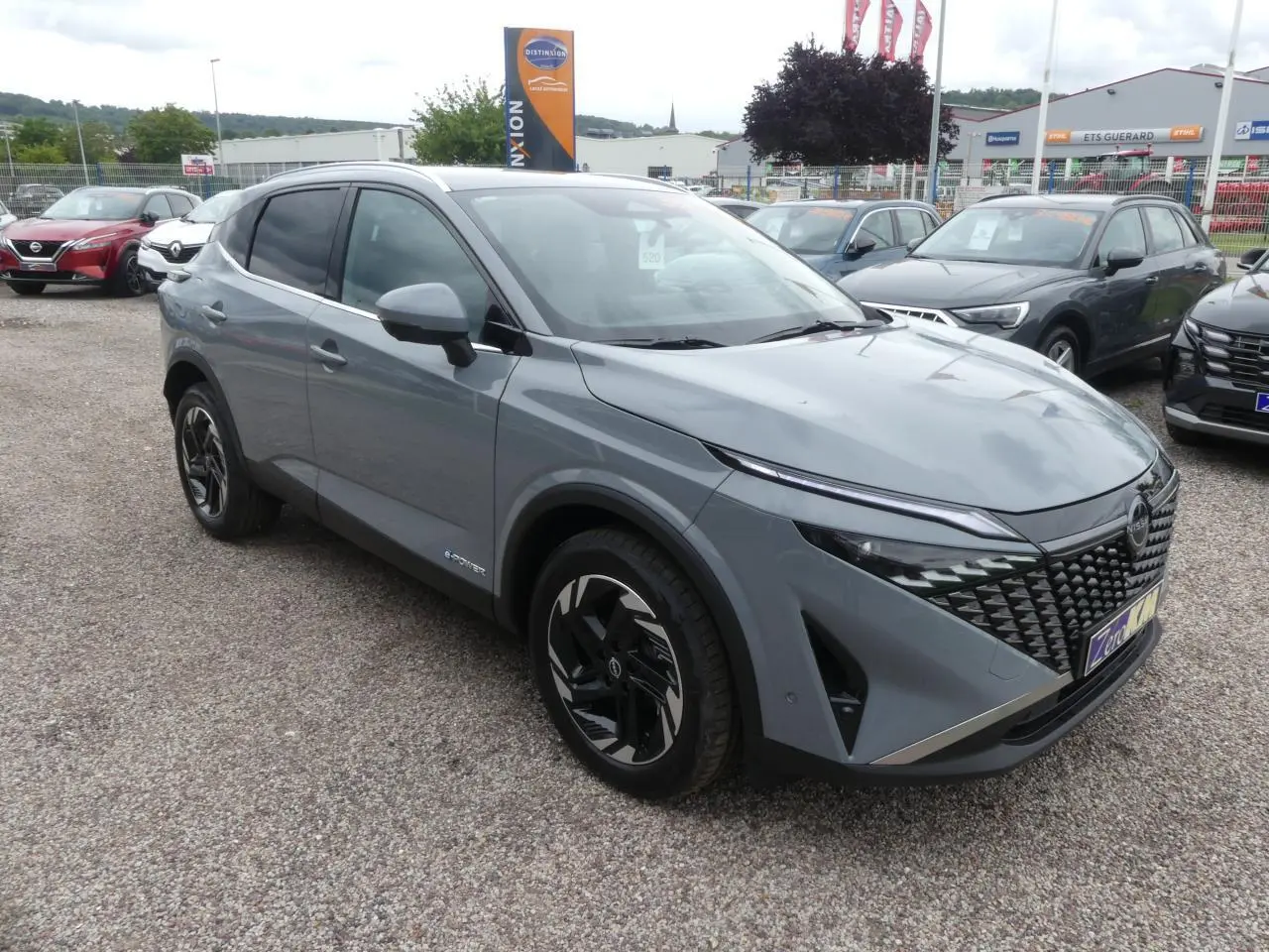 Nissan Qashqai 1.5 e-Power gris métallisé en 3/4 avant droit avec calandre distinctive et jantes alliage.