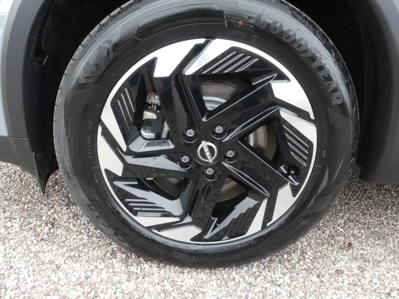 Gros plan sur la jante alliage bicolore noir et argentée d'un Nissan Qashqai gris métallisé côté avant droit.