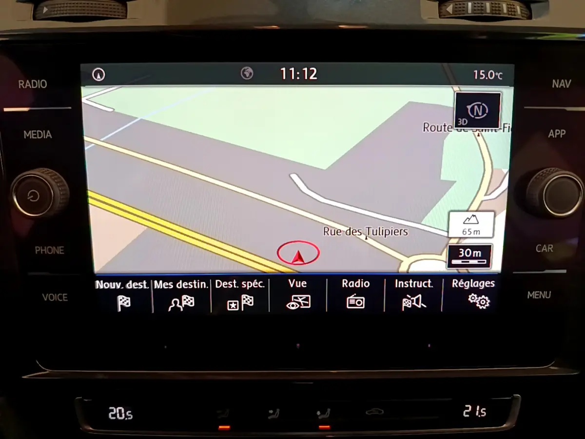Écran tactile central de navigation 3D dans Volkswagen Golf gris clair, affichant une carte routière et menus fonctionnels.