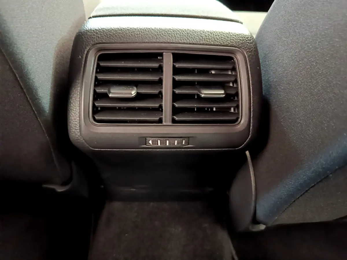 Grille d'aération arrière noire vue de face entre les sièges avant d'une Volkswagen Golf gris clair 2019.