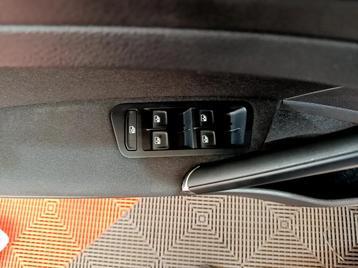 Panneau de commandes des vitres électriques côté conducteur dans une Volkswagen Golf gris clair 2019, intérieur noir.