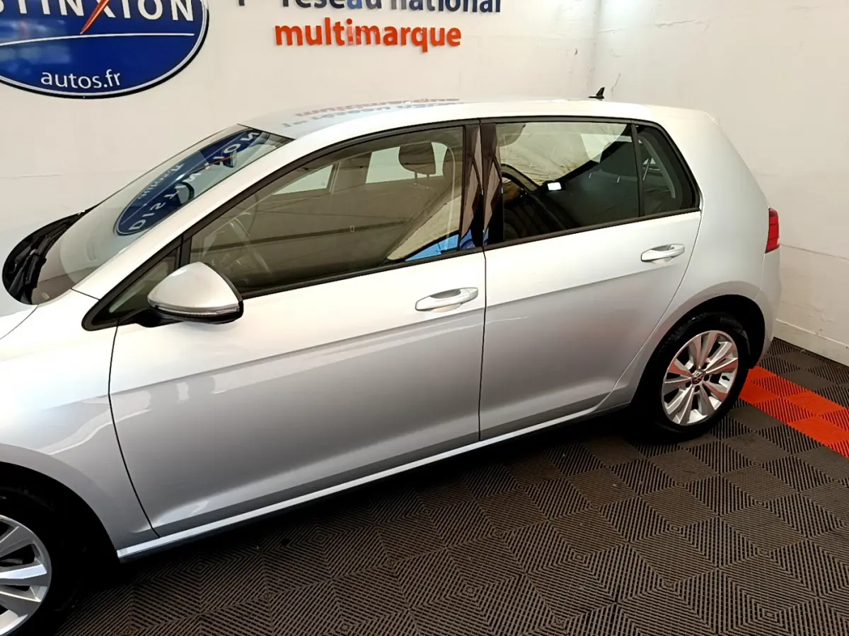 Profil côté gauche d'une Volkswagen Golf gris clair 2019, mettant en valeur ses lignes épurées et ses jantes alliage.