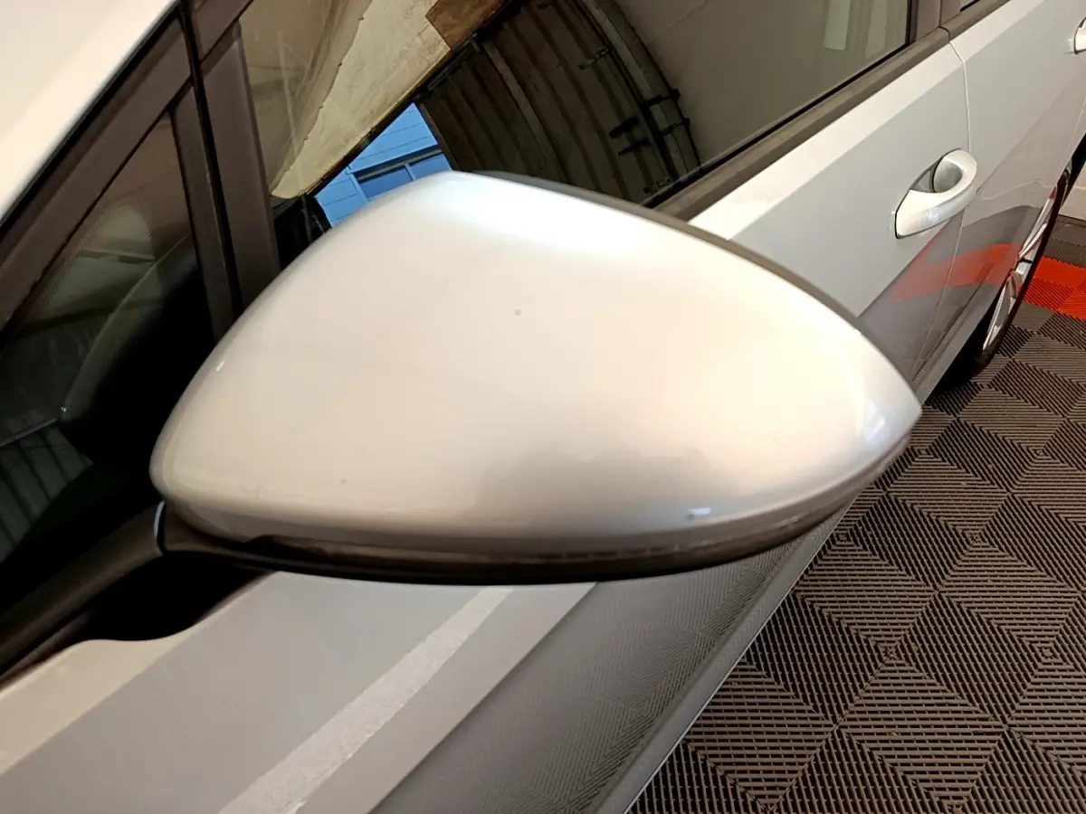 Rétroviseur côté gauche gris clair de la Volkswagen Golf 2019, vue rapprochée sur la portière et poignée.