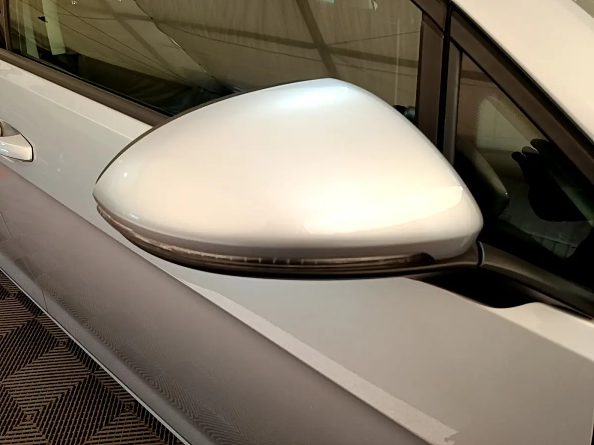 Rétroviseur droit gris clair de Volkswagen Golf 2019, vue rapprochée sur la porte avant côté conducteur.