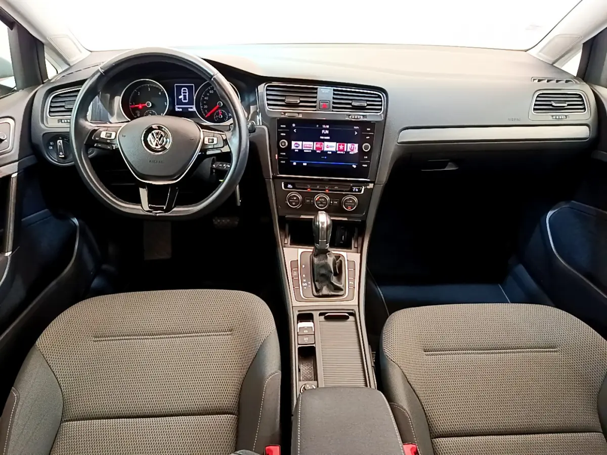 Vue intérieure avant de la Volkswagen Golf 1.6 TDI 2019, tableau de bord avec écran tactile et volant multifonctions noir.