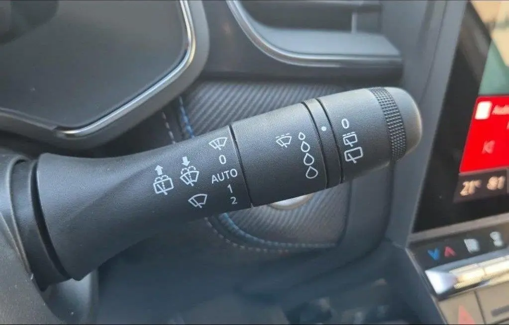 Gros plan sur la commande des essuie-glaces dans l’habitacle du Renault Captur gris Rafale, finition Esprit Alpine.