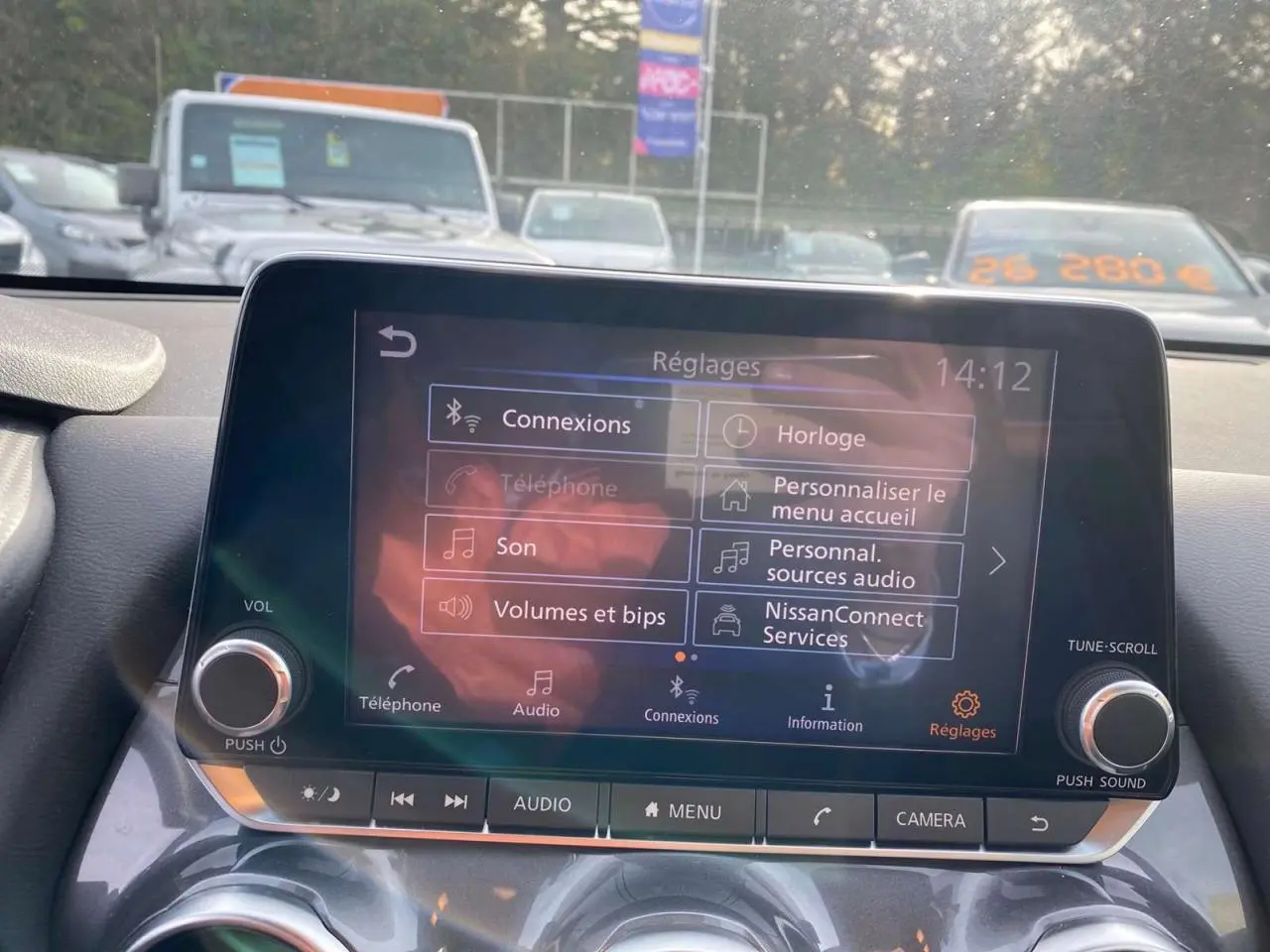 Écran tactile central du Nissan Juke 2024 affichant le menu réglages avec options de connexion et audio.
