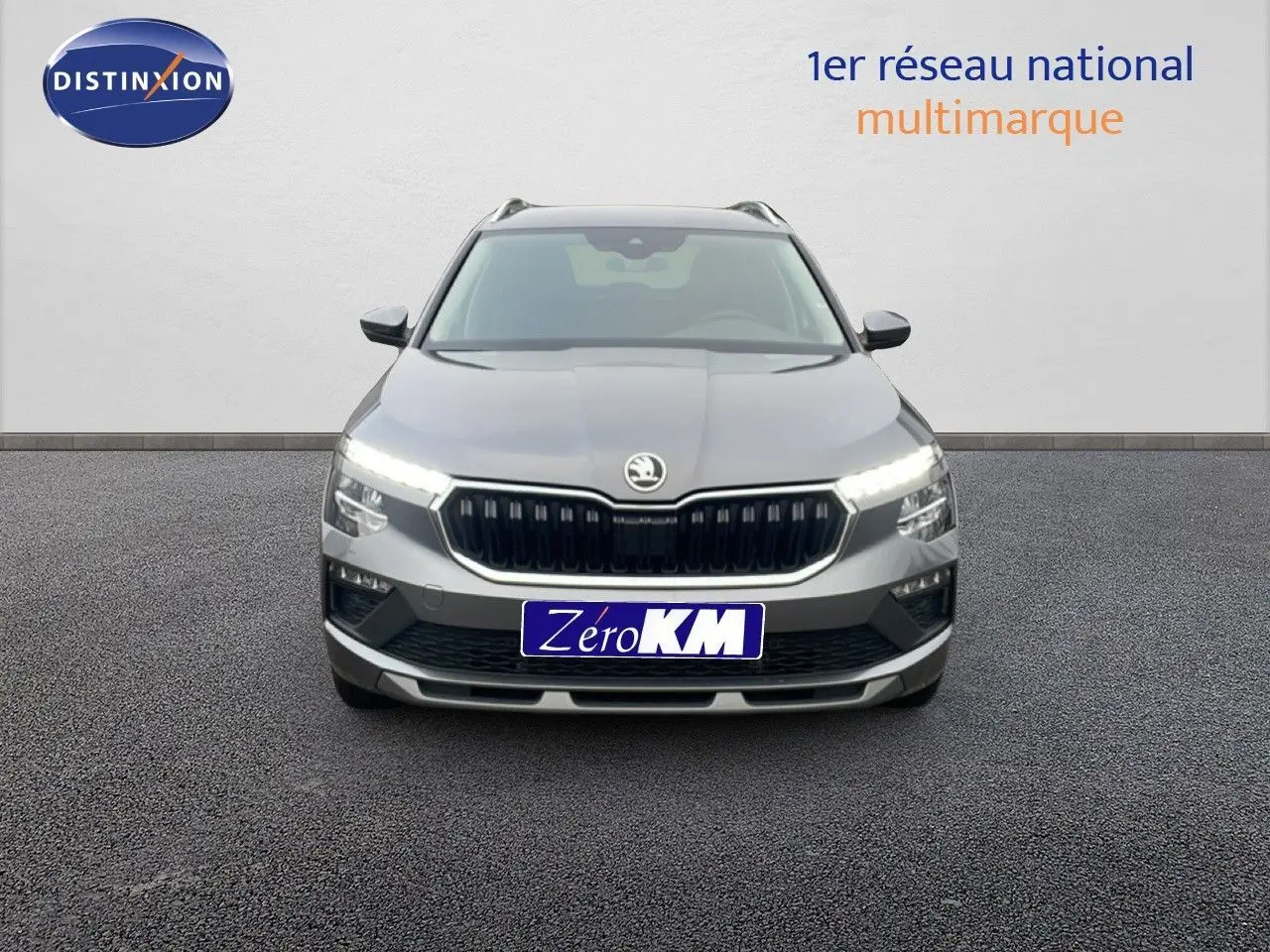 Vue frontale d'un Skoda Kamiq gris graphite métal 2025 avec calandre noire et feux LED allumés.