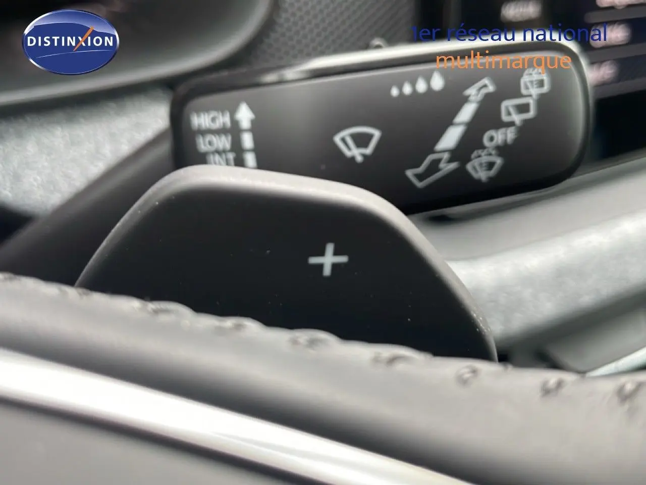 Gros plan sur la palette de changement de vitesse "+" derrière le volant du Skoda Kamiq gris graphite 2025.