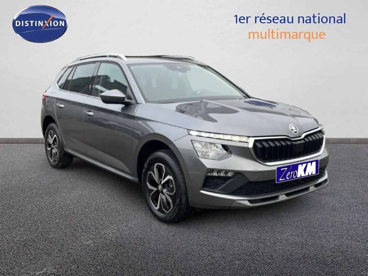 Vue 3/4 avant d'un Skoda Kamiq gris graphite métal 2025 avec calandre noire et jantes bi-ton.