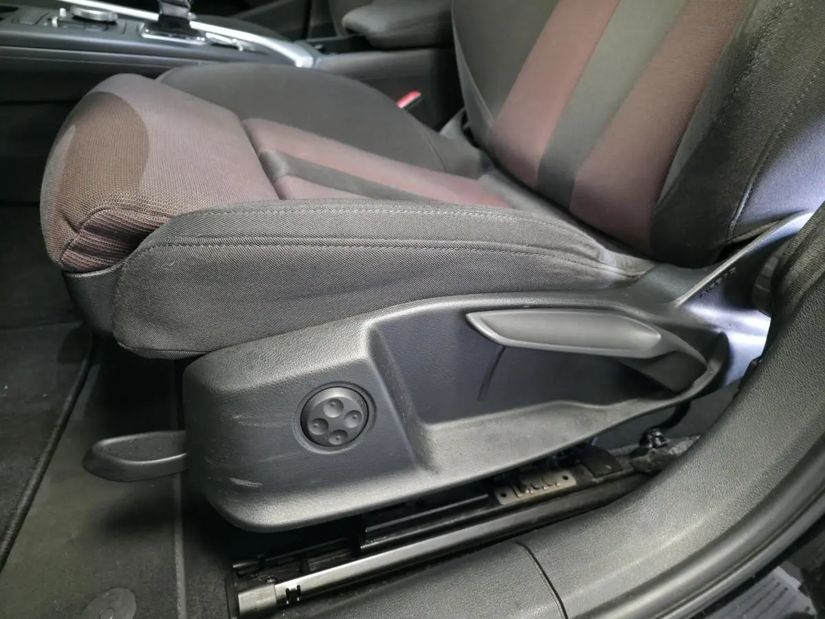 Gros plan sur le siège avant gauche noir et marron avec réglages manuels d'une Audi A4 Avant 2.0 TDI 2019.