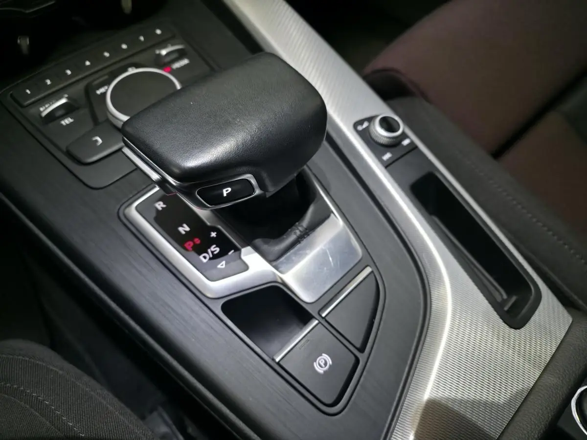 Gros plan sur le levier de vitesses automatique noir et la console centrale en aluminium brossé de l'Audi A4 Avant 2019.