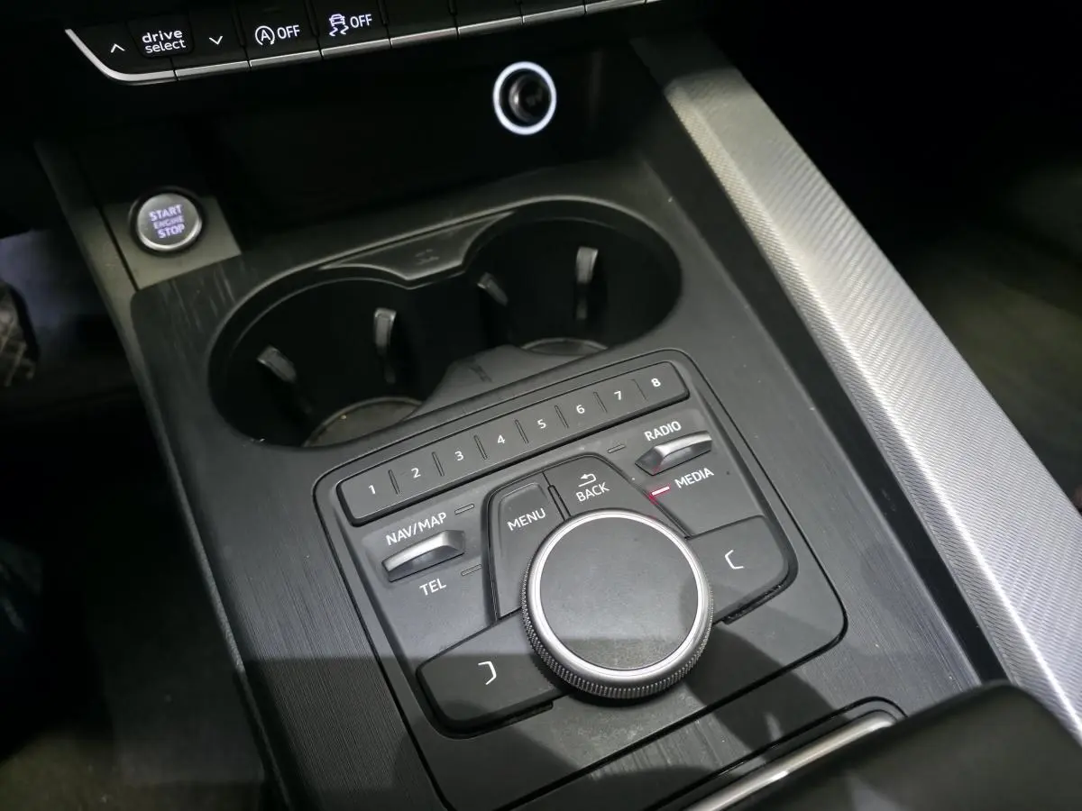Vue rapprochée de la console centrale noire de l'Audi A4 2019 avec commandes MMI et bouton Start/Stop.