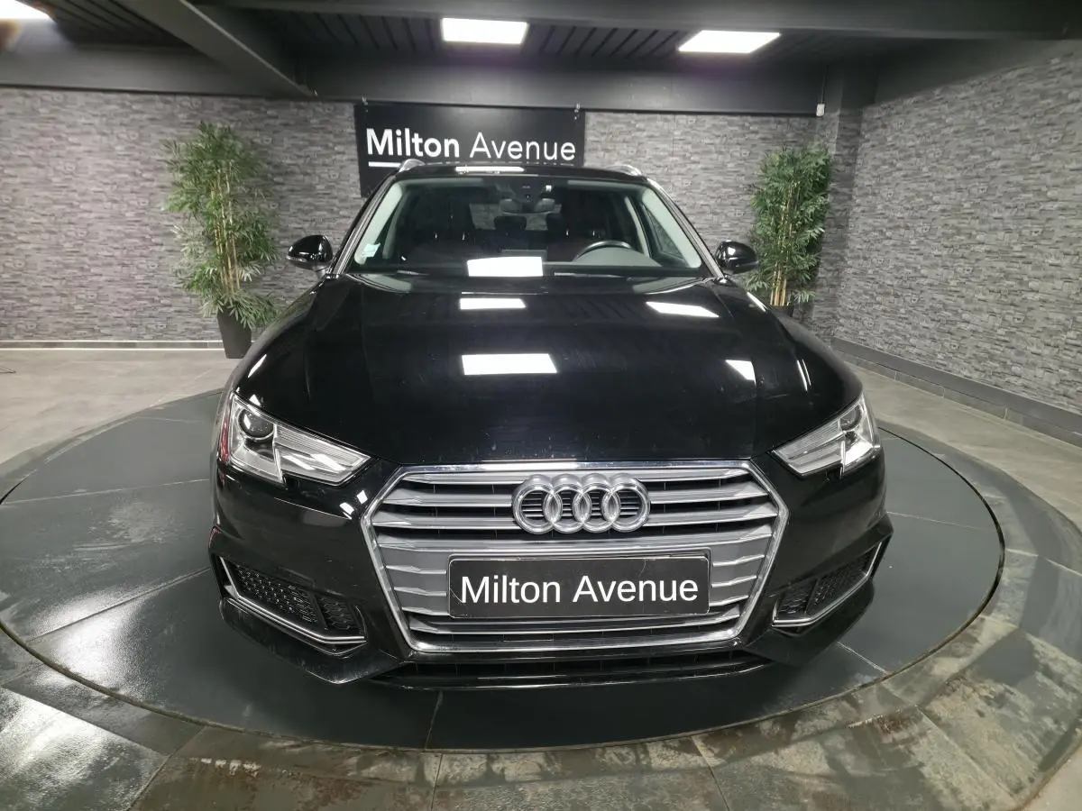 Audi A4 Avant noire vue de face, mettant en valeur sa calandre hexagonale et ses phares LED distinctifs.