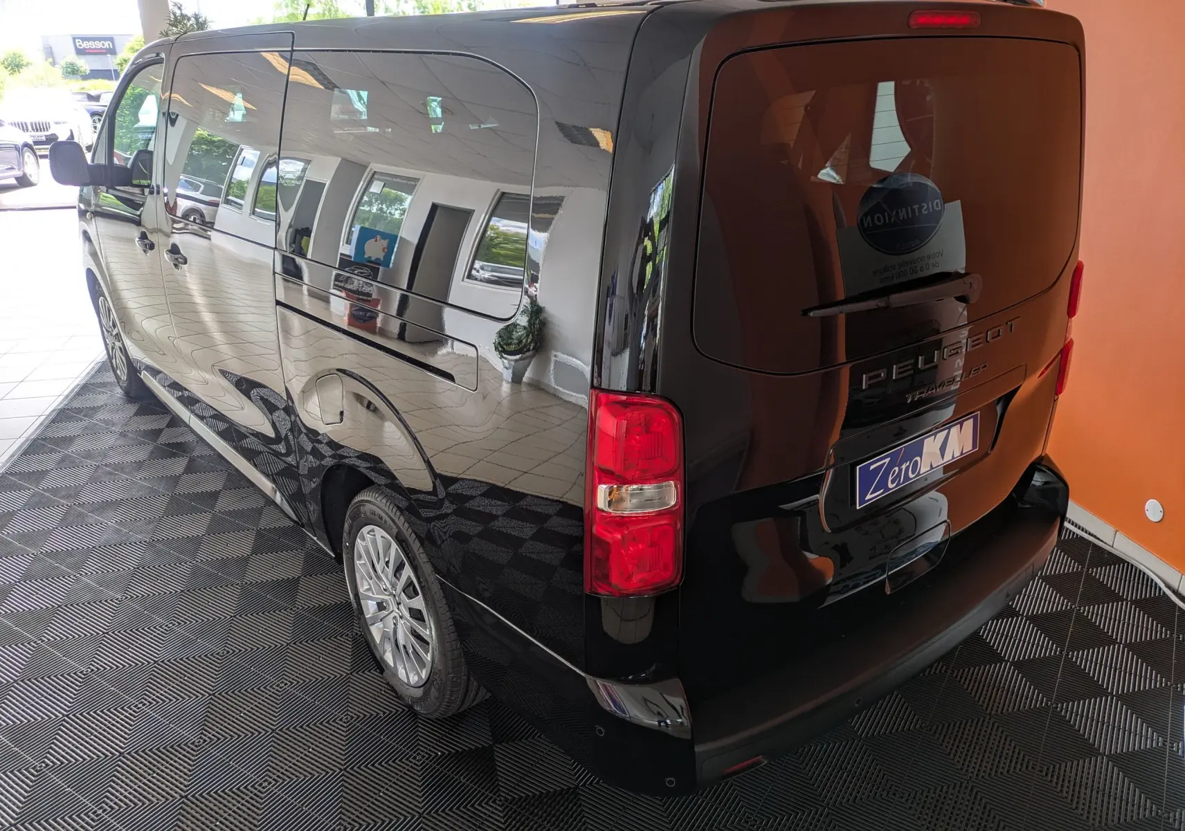 Vue 3/4 arrière droite du Peugeot Traveller noir 2026 avec hayon et vitres latérales teintées.