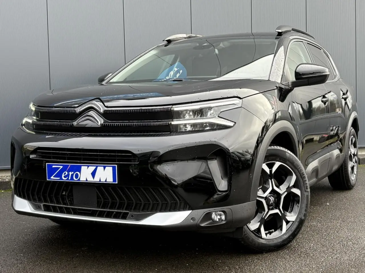 Vue 3/4 avant droit d'un Citroën C5 Aircross noir Perla avec jantes alliage bi-ton et calandre distinctive.