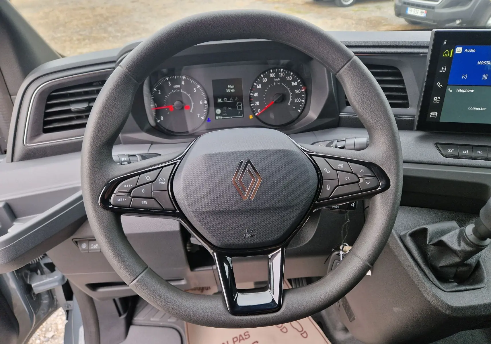Vue intérieure centrée sur le volant noir du Renault Master L2H2 2026 avec tableau de bord et écran multimédia visible.
