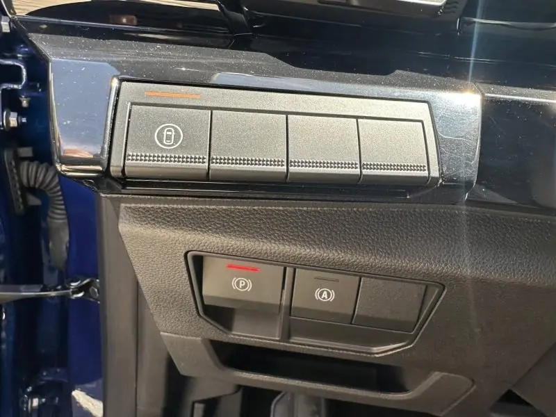 Gros plan sur les commandes de verrouillage et frein à main électrique du Renault Austral bleu Iron, côté gauche intérieur.