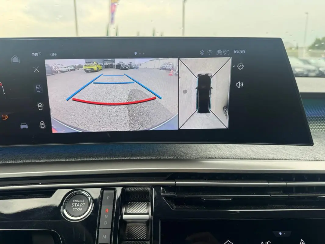 Vue intérieure du cockpit numérique du Peugeot 5008 Hybrid noir 2025, affichant la caméra de recul et l'écran tactile central.