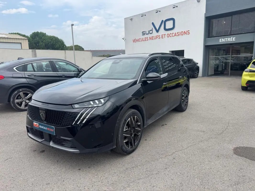 Peugeot 5008 Hybrid noir en 3/4 avant droit, avec jantes alliage 19 pouces et barres de toit visibles.