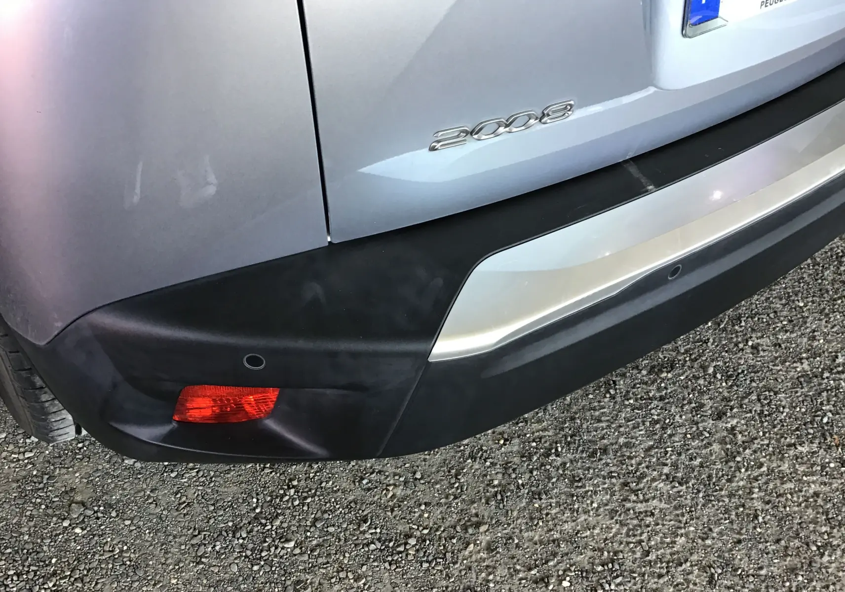 Gros plan sur le coin arrière droit gris Artense du Peugeot 2008 2022 avec feu rouge et logo 2008 visible.