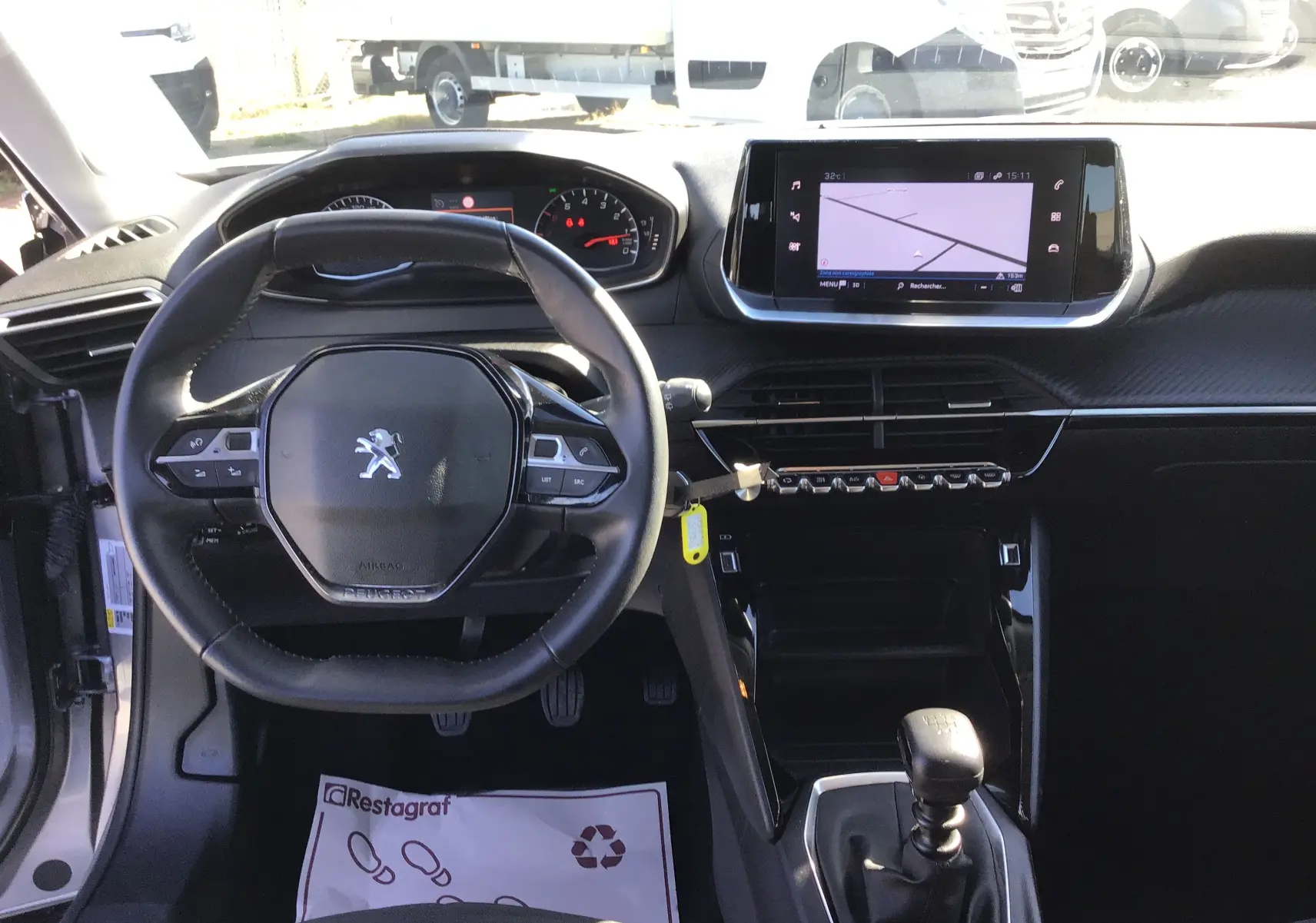 Vue intérieure avant du Peugeot 2008 1.5 BlueHDi 110 Active Pack gris, avec volant cuir, écran GPS et boîte manuelle.