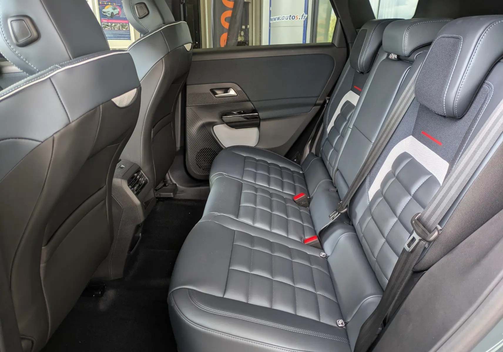 Vue intérieure côté droit des sièges arrière en cuir noir du Citroën C5 Aircross hybride 2026 avec ceintures grises et appuie-têtes.