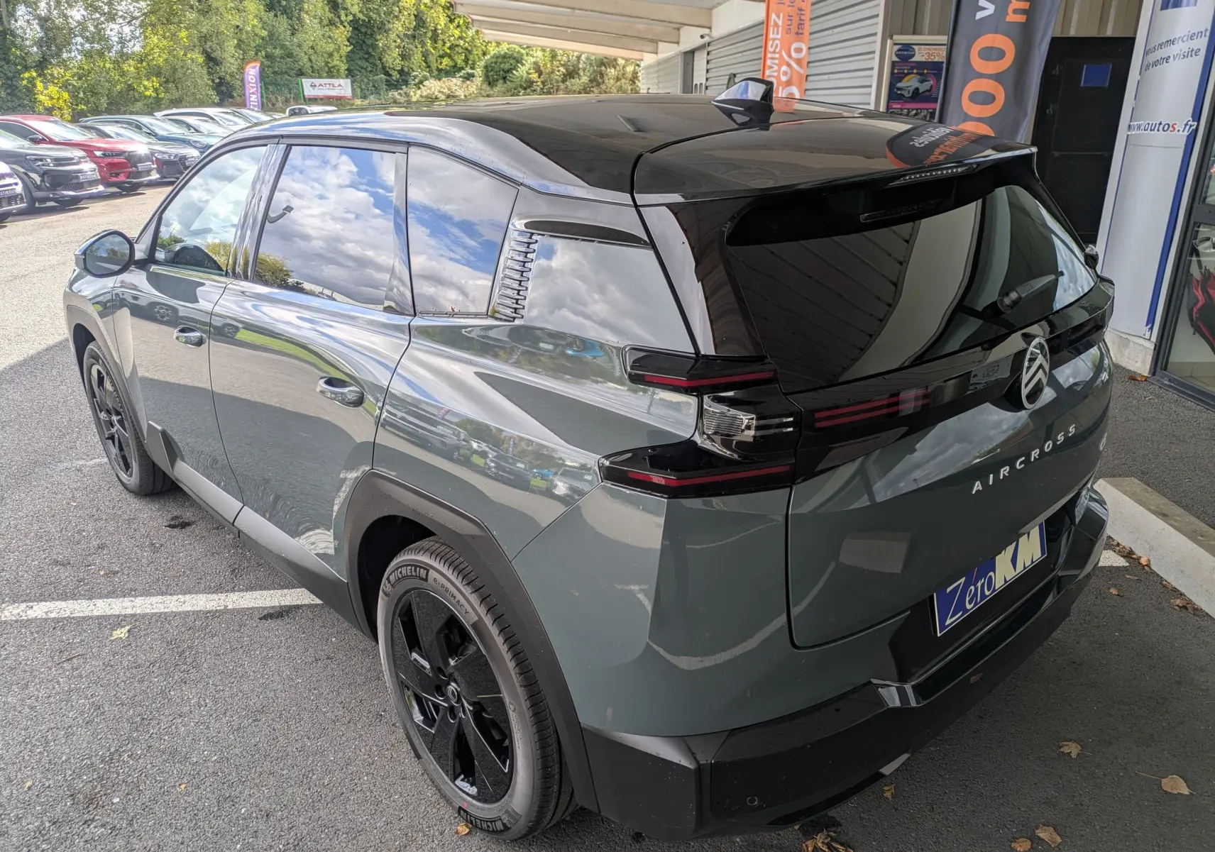 Vue 3/4 arrière droite d’un Citroën C5 Aircross hybride 2026 vert Astoria avec toit noir et jantes noires.