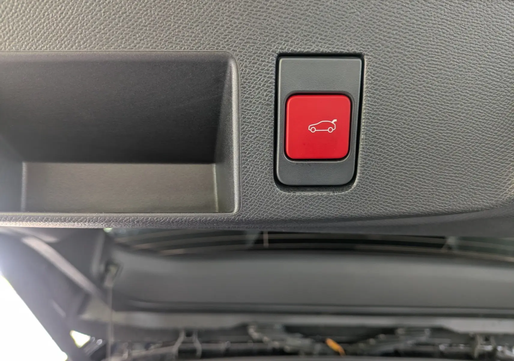 Bouton rouge de déverrouillage électrique du hayon sur le bord intérieur du coffre du Citroën C5 Aircross hybride 2026.