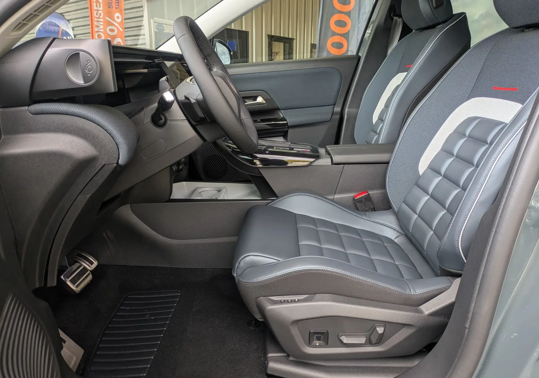 Vue intérieure côté conducteur du Citroën C5 Aircross hybride 2026, sièges cuir gris avec surpiqûres et tableau de bord moderne.