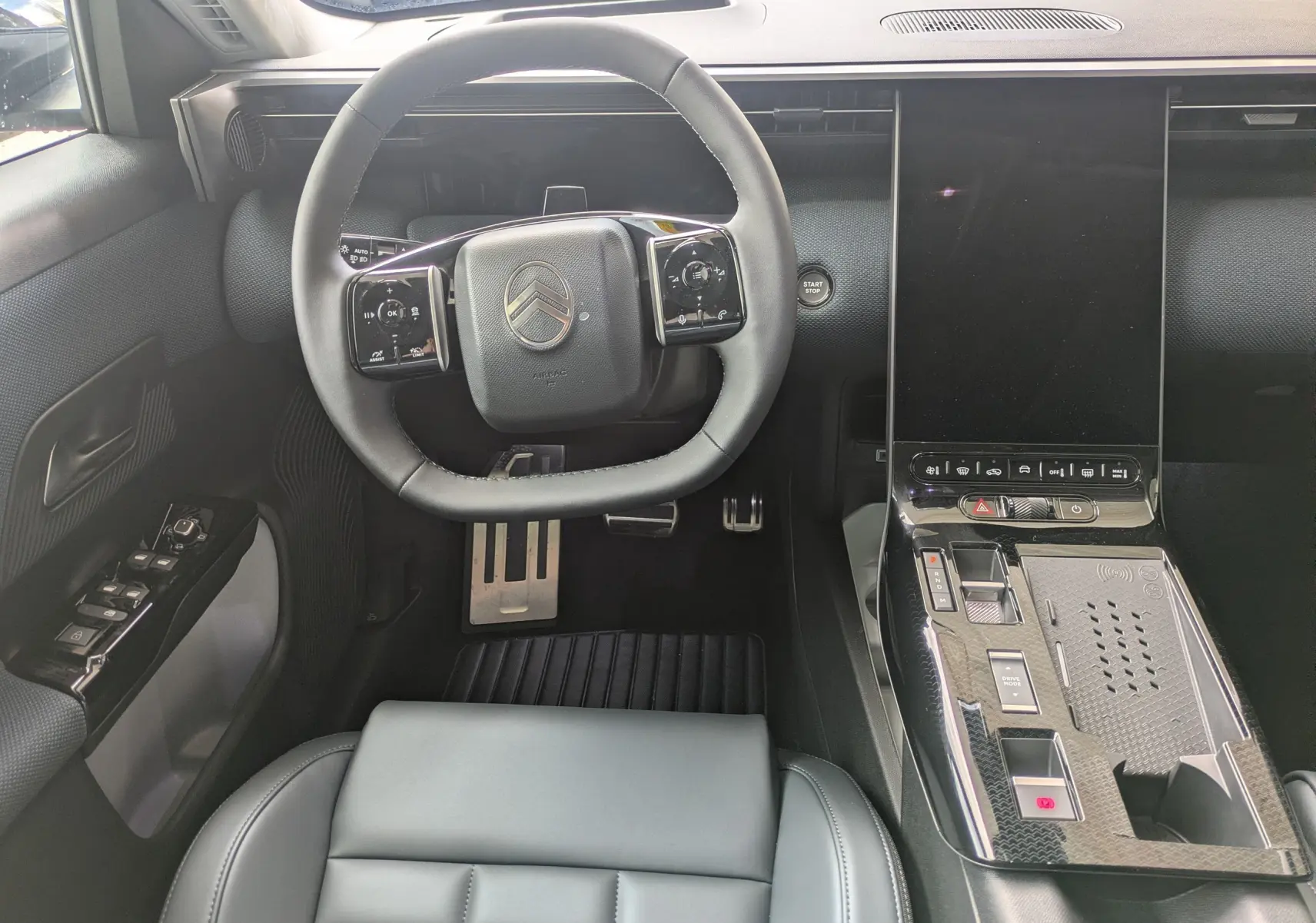 Vue intérieure centrée sur le volant et la console centrale noire du Citroën C5 Aircross hybride 2026.