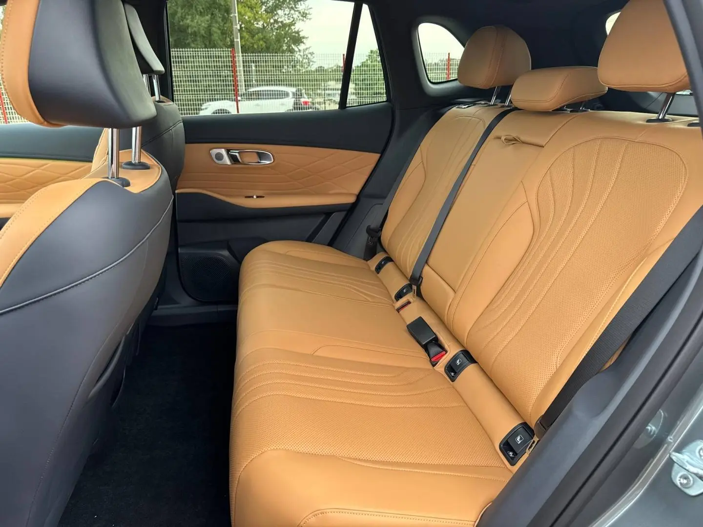 Vue latérale de l'intérieur arrière du Geely STARRAY 2026 avec sièges en cuir beige et panneaux de porte assortis.