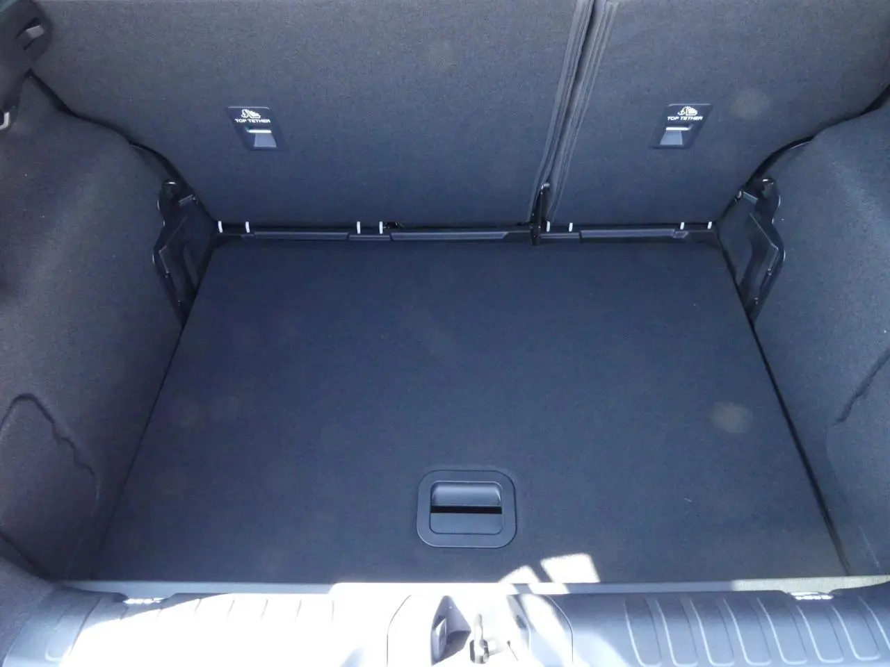 Coffre spacieux et tapis de sol plat du Ford Puma 2025 gris métallisé, vue intérieure arrière sans chargement.