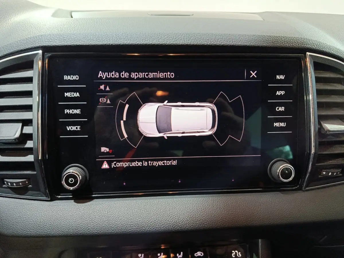 Écran tactile central montrant l'aide au stationnement du Skoda Karoq 2024, interface en espagnol.