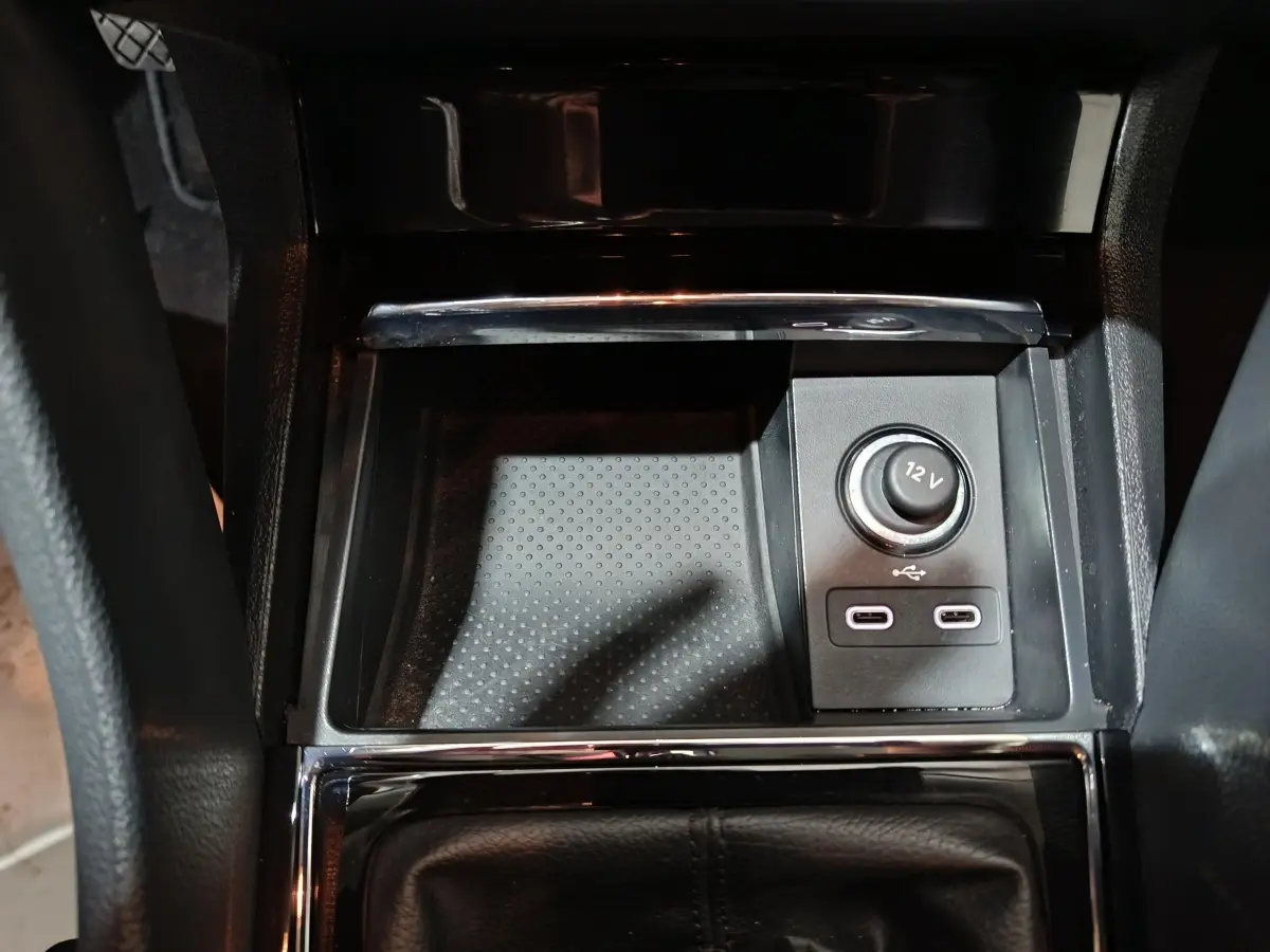 Gros plan sur la console centrale noire du Skoda Karoq 2024 avec prise 12V et deux ports USB-C.