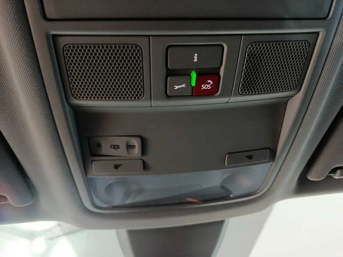 Vue en contre-plongée du plafonnier gris avec boutons SOS et éclairage dans un Skoda Karoq 2024 diesel.