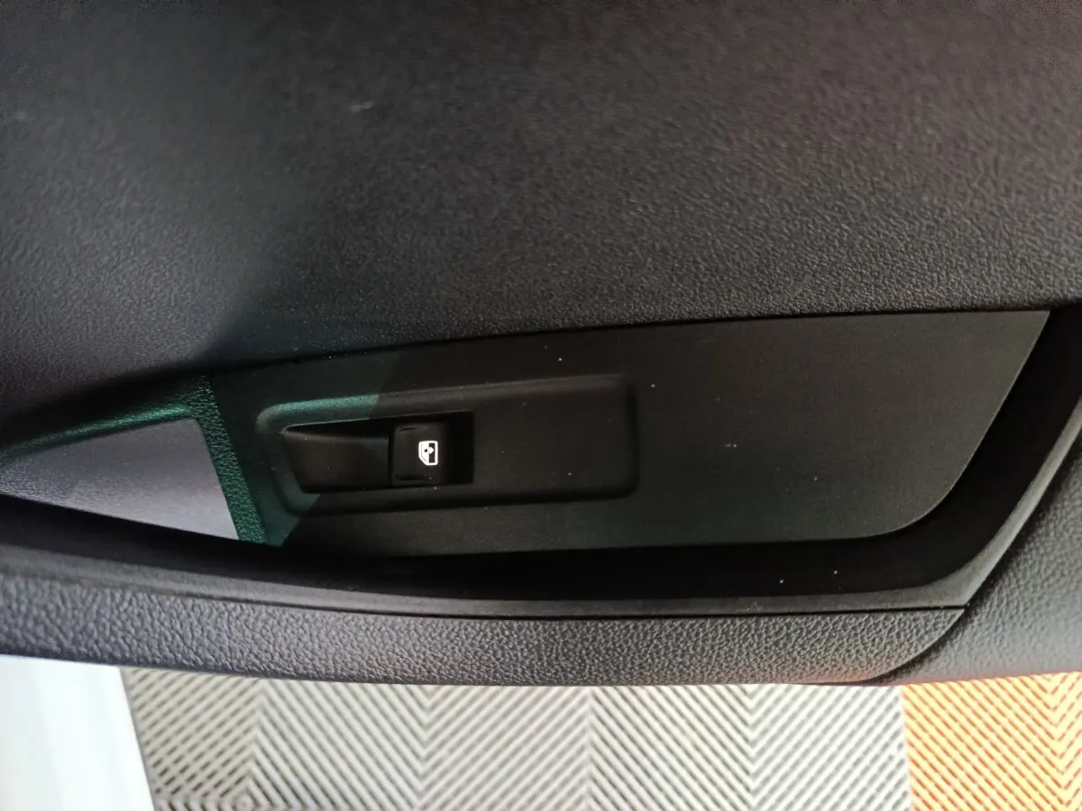 Gros plan sur l'interrupteur de fermeture électrique de coffre dans l'habitacle d'un Skoda Karoq 2024.