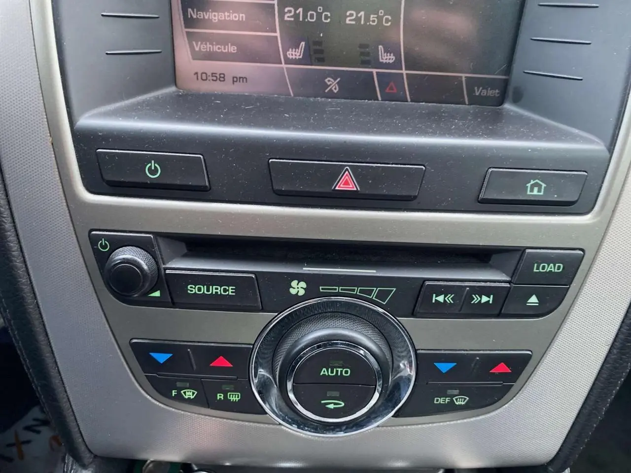 Tableau de bord du Jaguar XK 4.2i V8 2009, zoom sur commandes climatisation et écran multifonction.